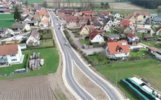 Luftaufnahme der Häuser, der Hauptstraße und der umliegenden Felder in der Nachbarschaft.