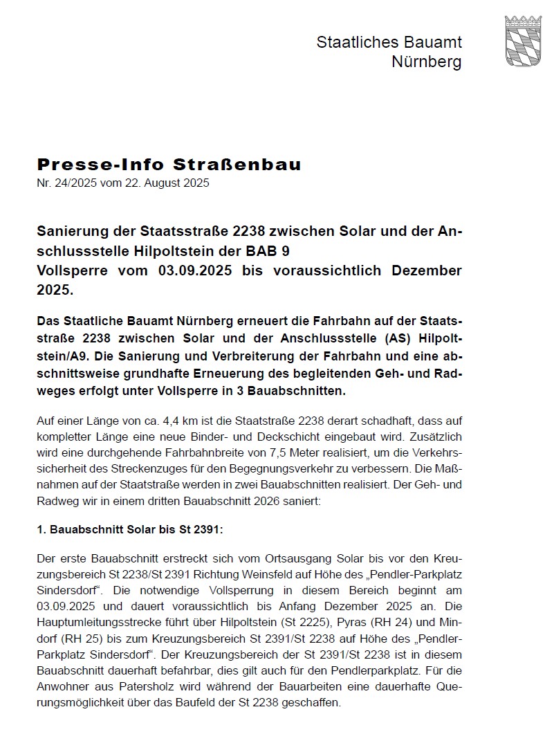 Arbeiter und Fahrzeuge erneuern eine Straße mit Asphalt; Bäume im Hintergrund.